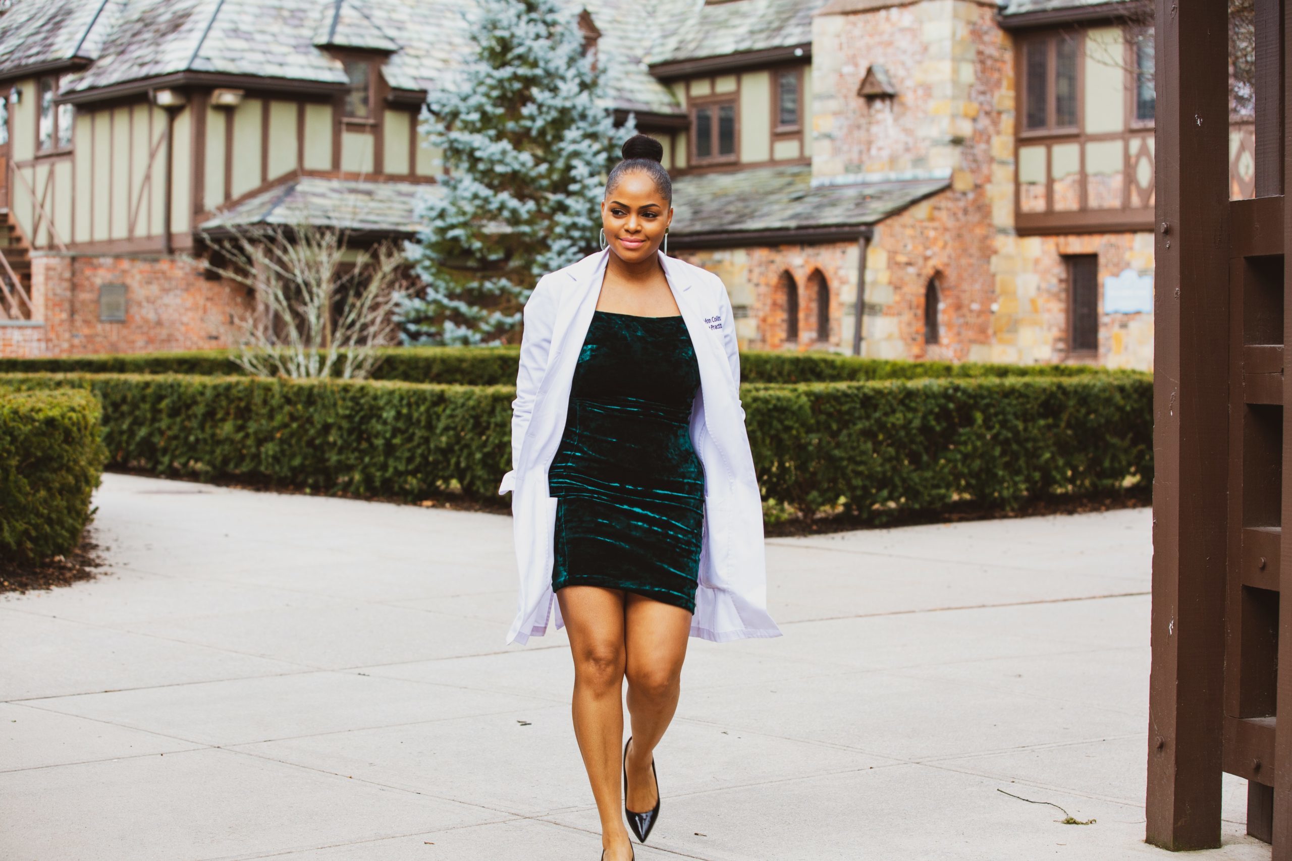 woman-in-green-dress-and-white-coat-walking-on-gray-concrete-3714687
